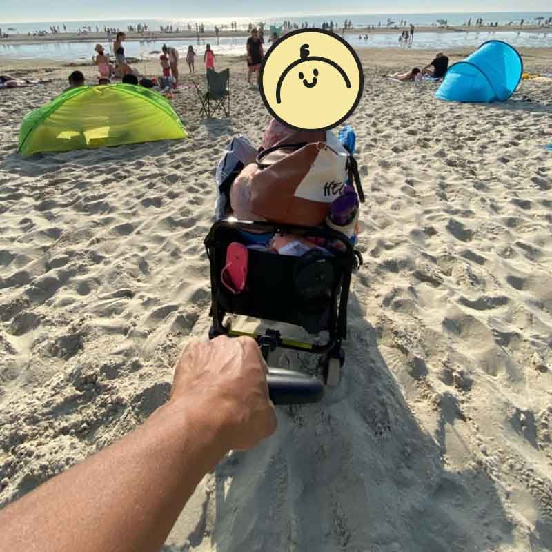 Strandwagen mit einem Kind darin